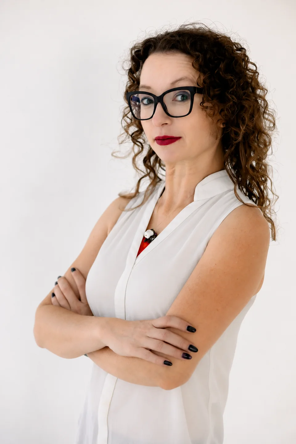 Lindsey Yagi-Hatake with arms crossed, wearing glasses and a white blouse.